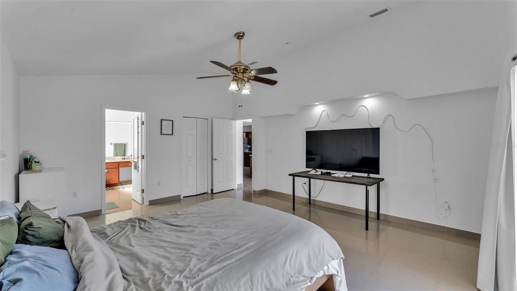 587 Drayton Road Winter Haven, FL 33884 - Photo 27 of 40 a bedroom with a bed and a flat screen tv