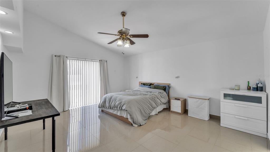 587 Drayton Road Winter Haven, FL 33884 - Photo 28 of 40 a bedroom with a bed and a chandelier