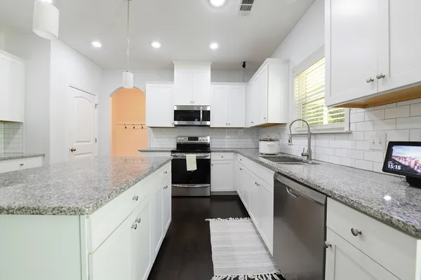 a kitchen with stainless steel appliances granite countertop a sink stove and cabinets