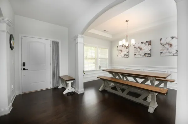 a living room with dining room furniture and a chandelier