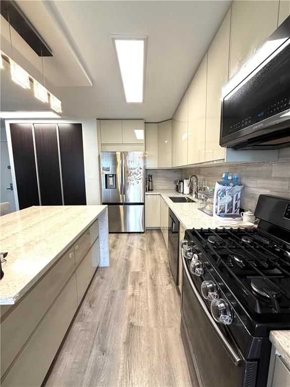 501 Surf Avenue, Unit 23M Brooklyn, NY 11224 - Photo 6 of 24 a kitchen with wooden cabinets and a stove top oven