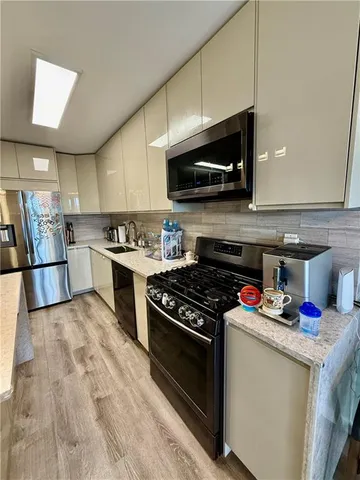 a kitchen with stainless steel appliances granite countertop a stove and a microwave