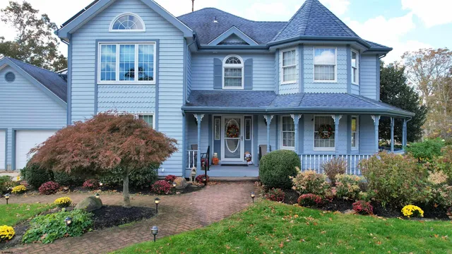 a front view of a house with a garden and plants