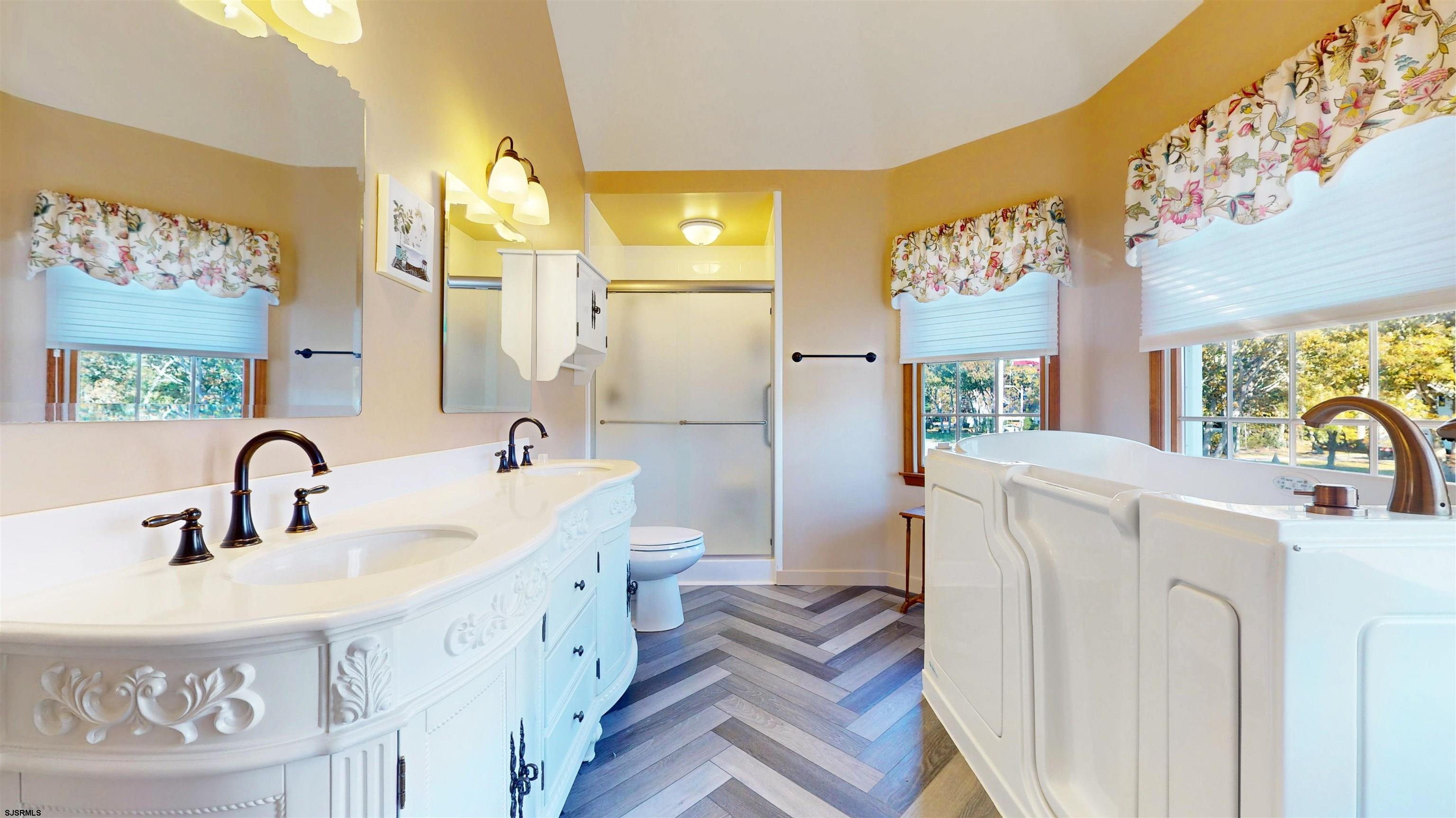 46 Victoria Lane Ocean View, NJ 08230 - Photo 21 of 66 a spacious bathroom with a sink a mirror a bathtub and next to a window