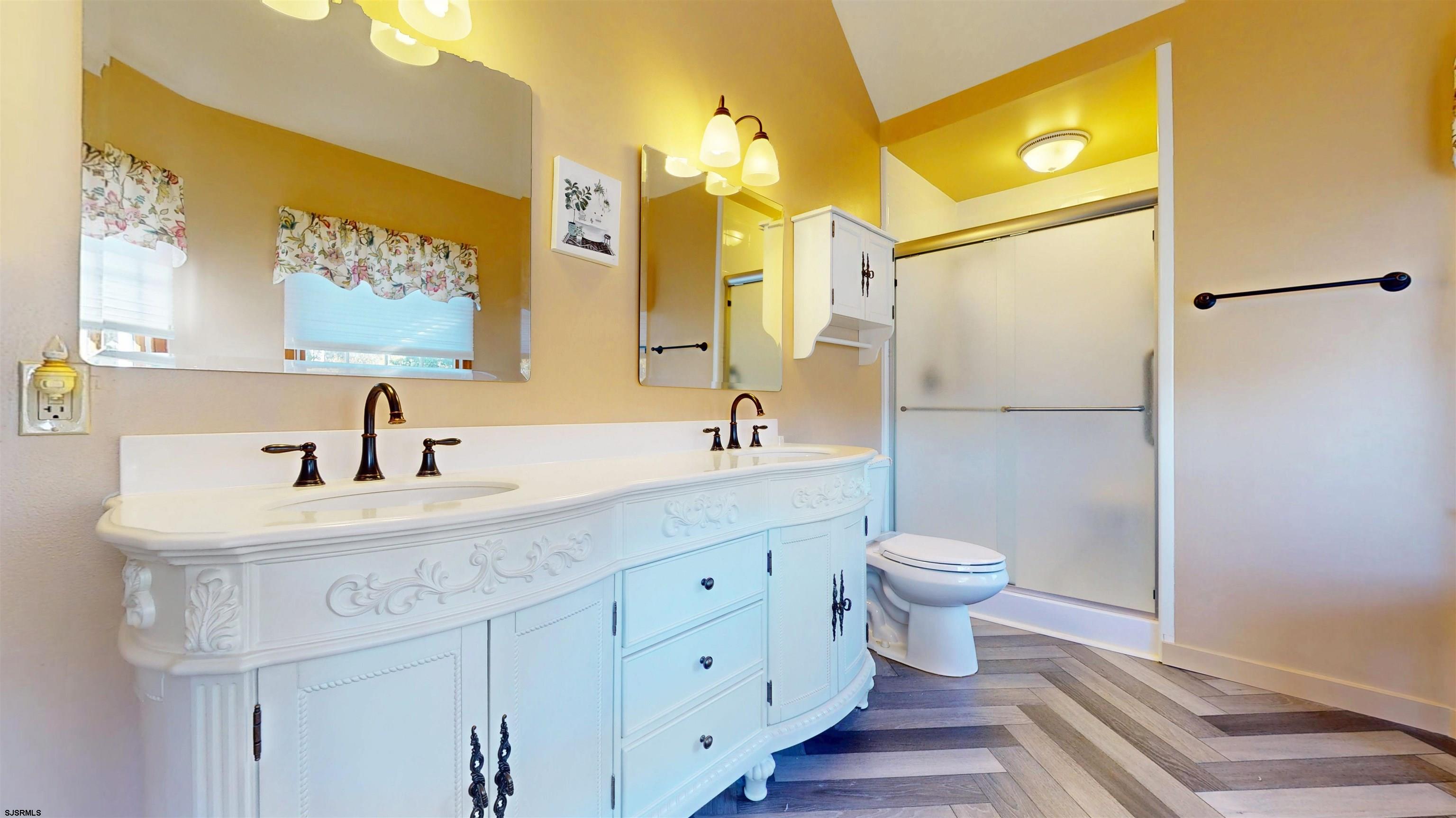 46 Victoria Lane Ocean View, NJ 08230 - Photo 22 of 66 a bathroom with a sink a toilet and a large mirror