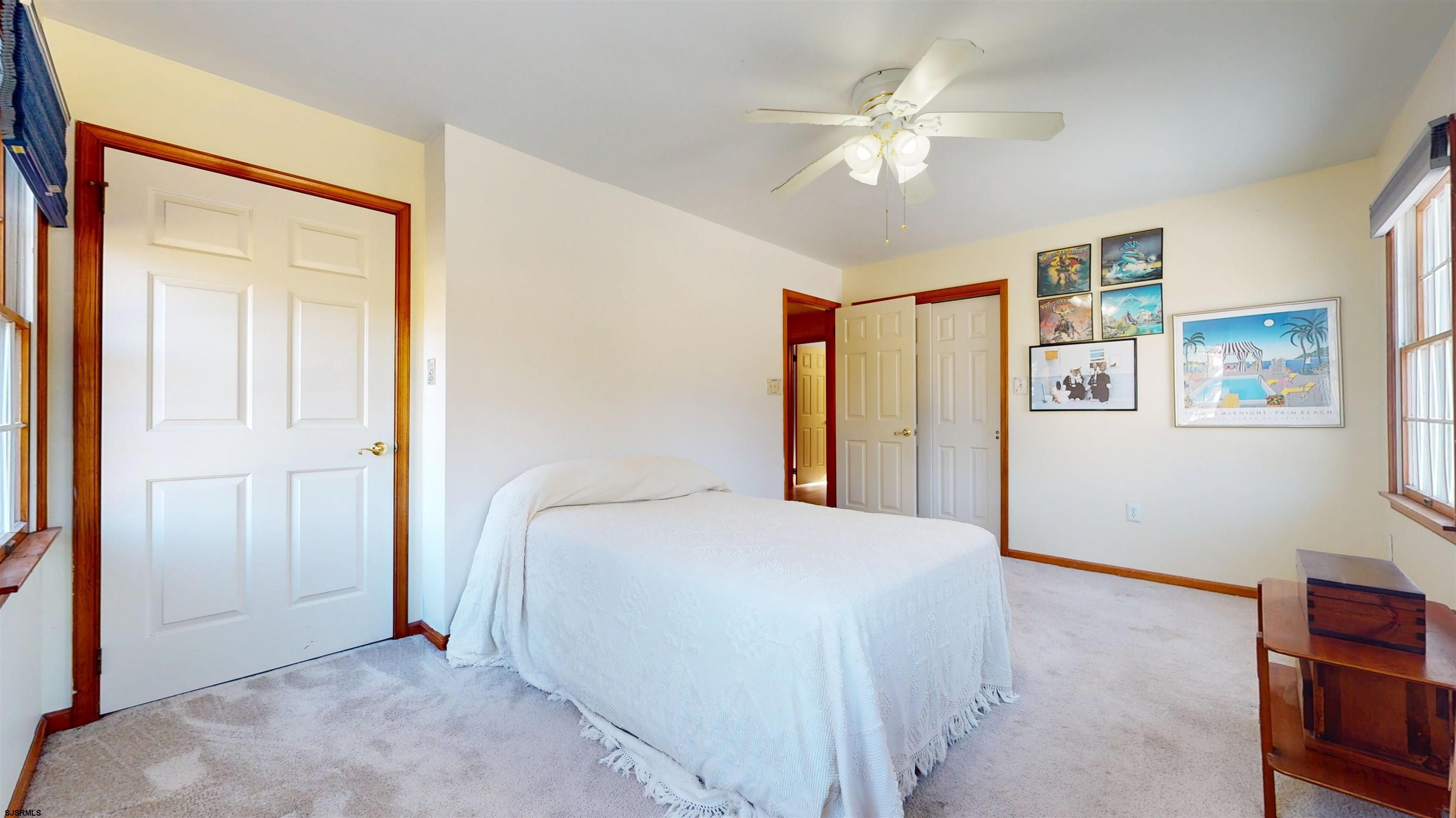 46 Victoria Lane Ocean View, NJ 08230 - Photo 25 of 66 a bedroom with a large bed and a chandelier
