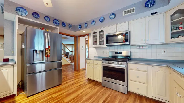 a kitchen with stainless steel appliances granite countertop a refrigerator and a stove top oven