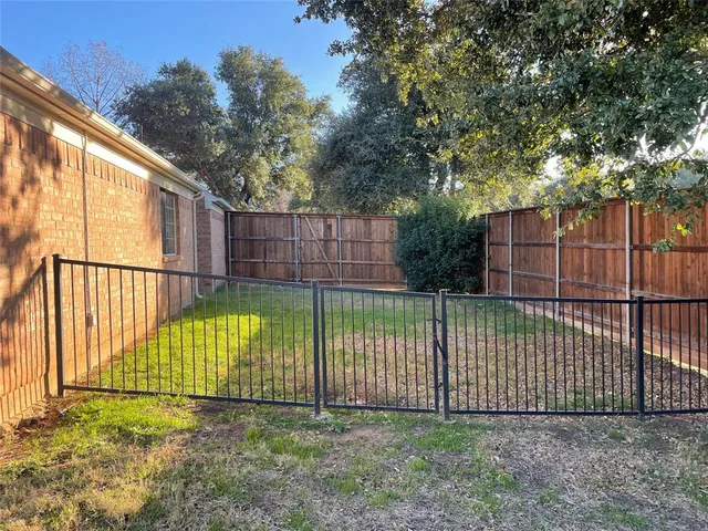 a view of a backyard with a fence