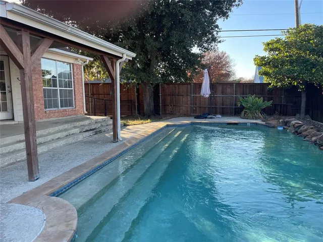 a view of a backyard with table and chairs and wooden fence