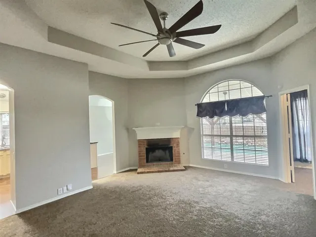 an empty room with windows and fireplace