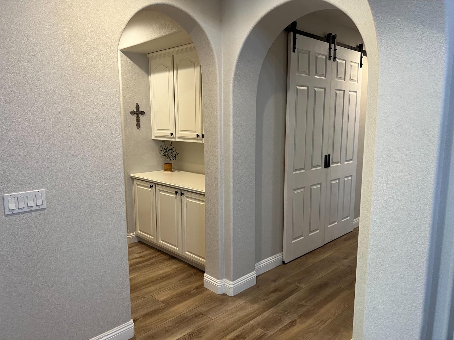 1135 North Perry Avenue Clovis, CA 93611 - Photo 13 of 27 a view of a hallway with wooden floor and a bathroom