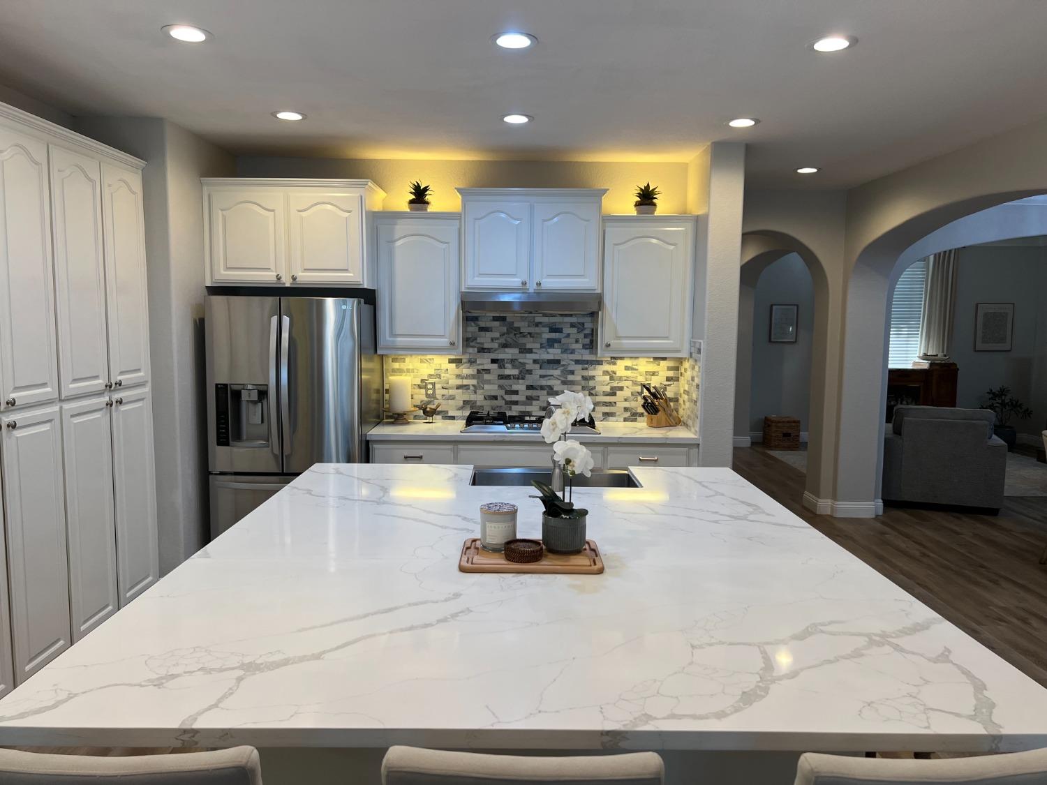 1135 North Perry Avenue Clovis, CA 93611 - Photo 5 of 27 a kitchen with stainless steel appliances kitchen island granite countertop a refrigerator and cabinets
