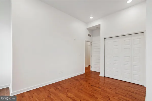 a view of an empty room with wooden floor