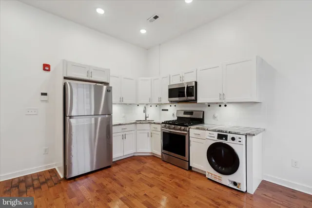 a kitchen with a refrigerator sink and stove top oven