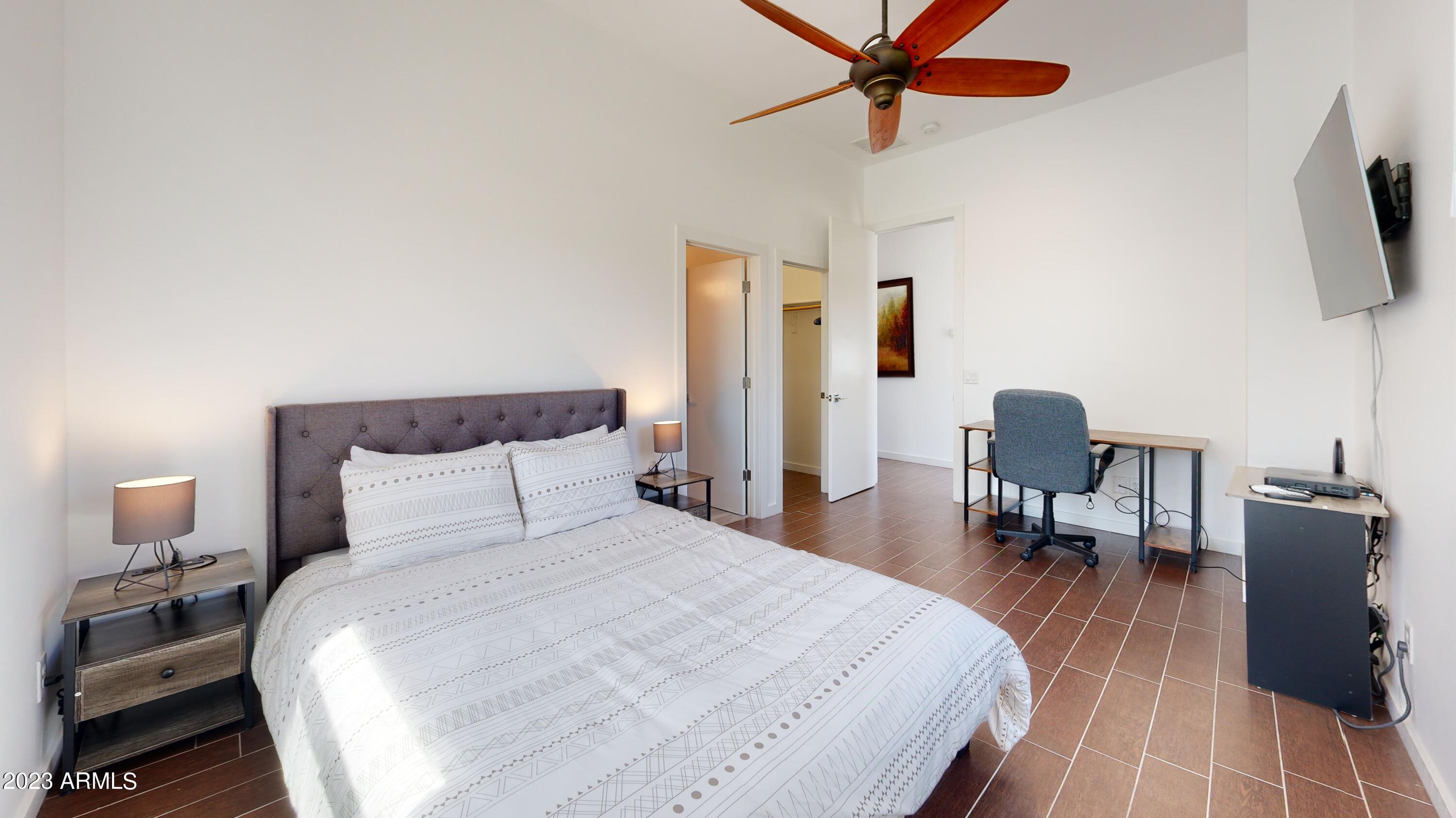 1202 East Colter Street Phoenix, AZ 85014 - Photo 22 of 30 a bedroom with a bed a flat screen tv and a chandelier