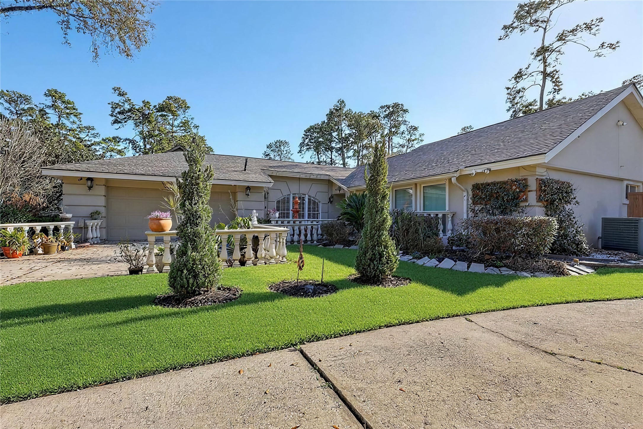 a front view of a house with a yard and potted plants