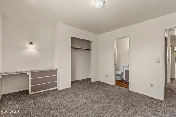 an empty room with windows and closet