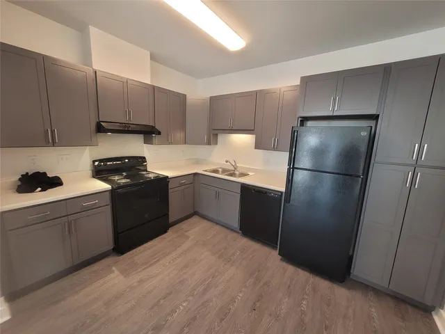 a kitchen with a refrigerator sink and cabinets