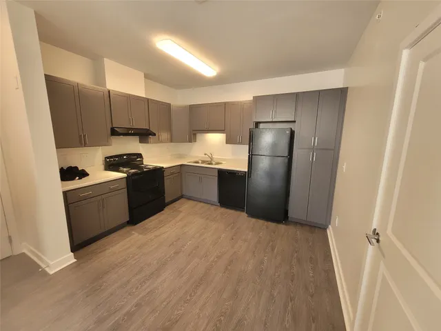 a kitchen with stainless steel appliances a refrigerator a sink a stove a microwave and cabinets