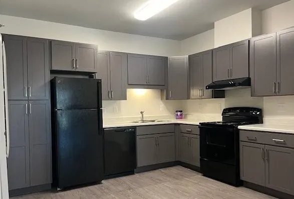 a kitchen with a sink a refrigerator and cabinets