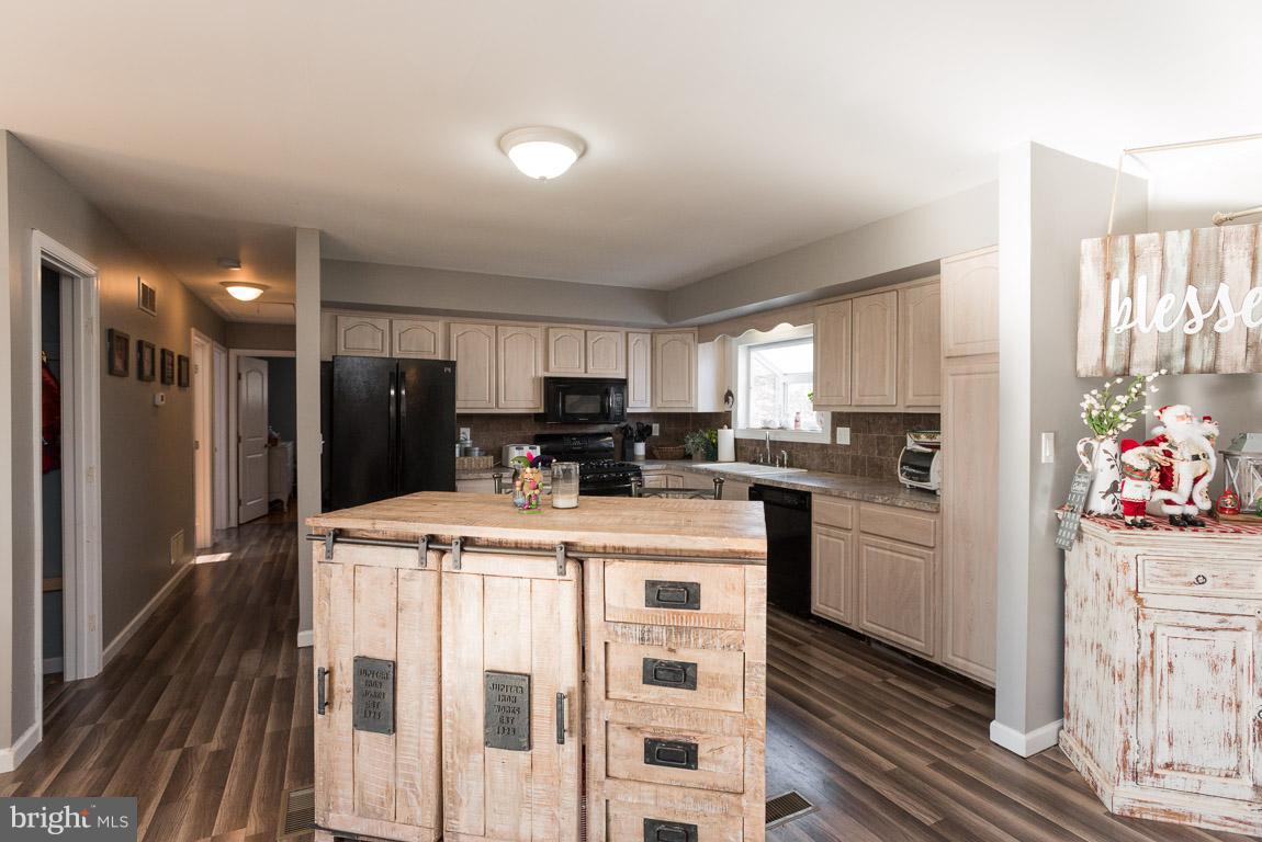 3201 Hunt Road Fallston, MD 21047 - Photo 7 of 29 a kitchen with stainless steel appliances kitchen island granite countertop a refrigerator a sink a stove and white cabinets with wooden floor