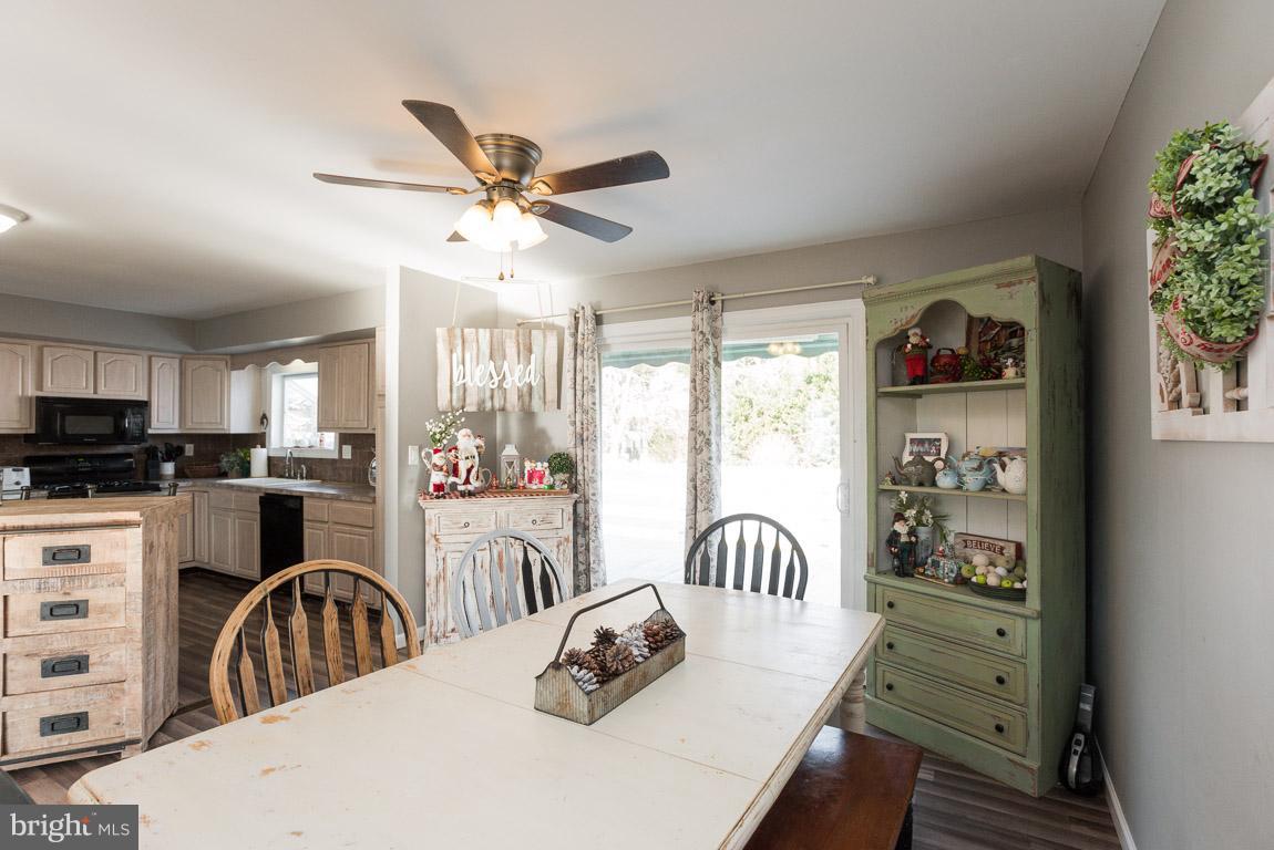 3201 Hunt Road Fallston, MD 21047 - Photo 9 of 29 a kitchen with stainless steel appliances granite countertop a refrigerator a stove a sink dishwasher a dining table and chairs with wooden floor