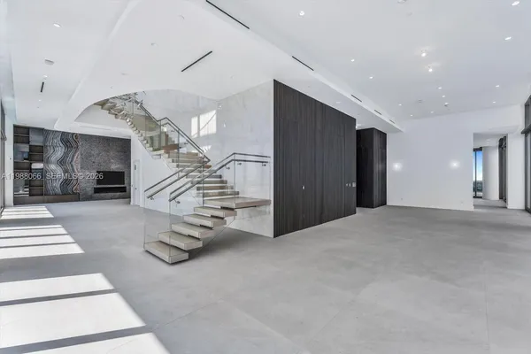 an empty room with wooden floor and stairs