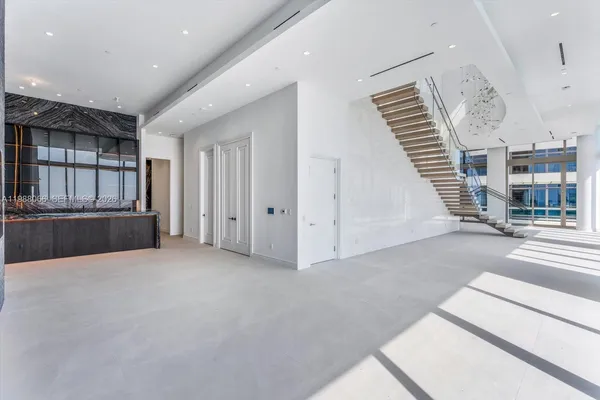 a living room with stainless steel appliances furniture a fireplace and a projector