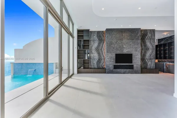 a view of an empty room with a fireplace and a window