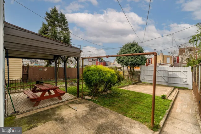 a view of a patio with table and chairs potted plants and a large tree