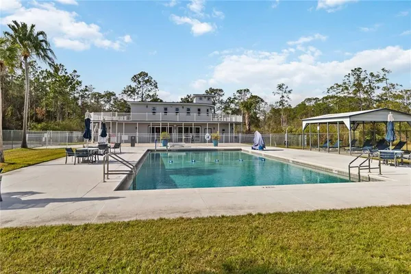 a view of a swimming pool with a patio and a yard