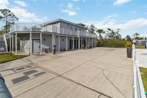 a view of a house with a barbeque and wooden floor