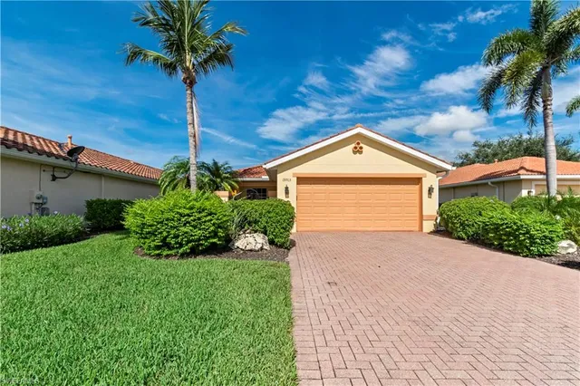 a view of a house with a yard and palm tree
