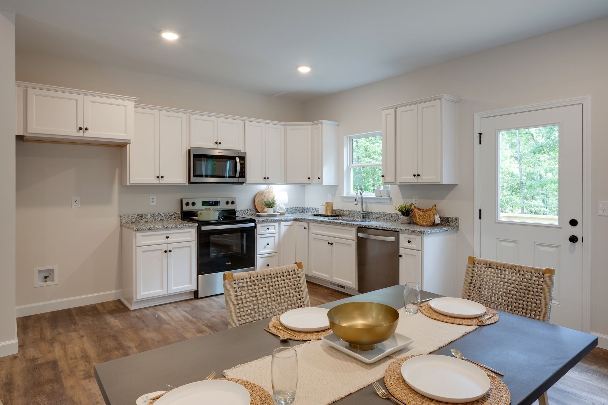 766 Billy Wynn Road Dickson, TN 37055 - Photo 10 of 31 a kitchen with a sink a stove a kitchen island and chairs with wooden floor