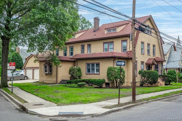a front view of a house with a yard and potted plants