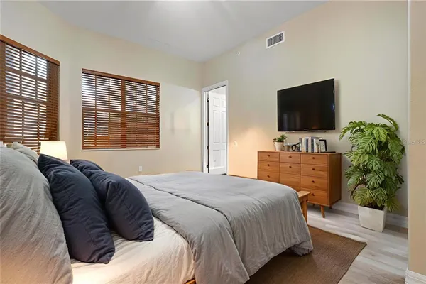 a spacious bedroom with a large bed and a chandelier fan