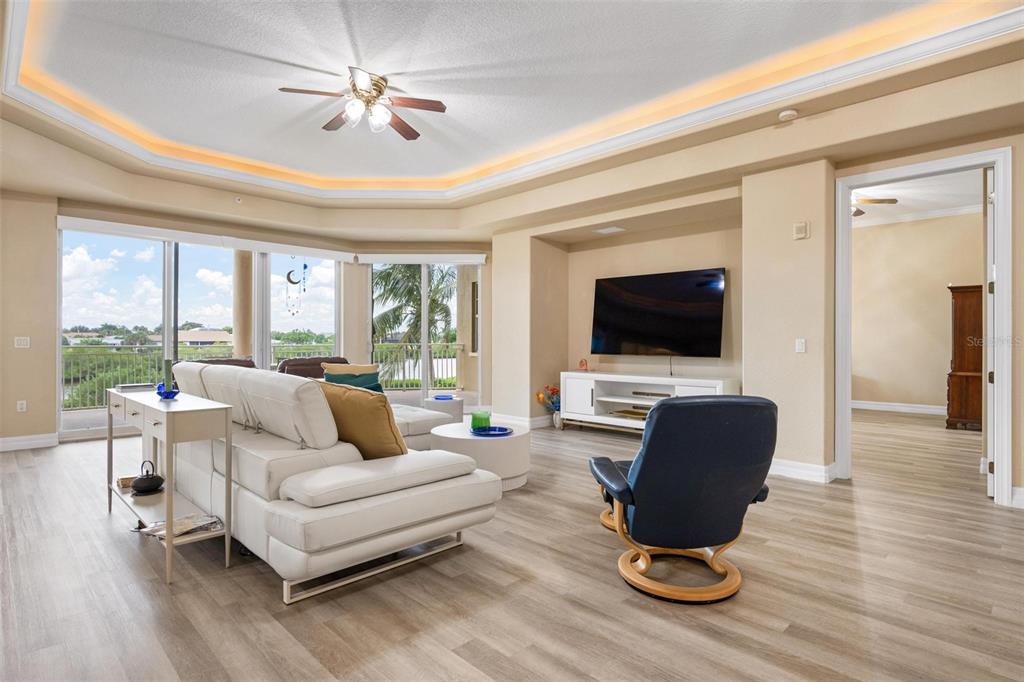6100 Jessie Harbor Drive, Unit 202 Osprey, FL 34229 - Photo 35 of 83 a living room with furniture a flat screen tv and a large window