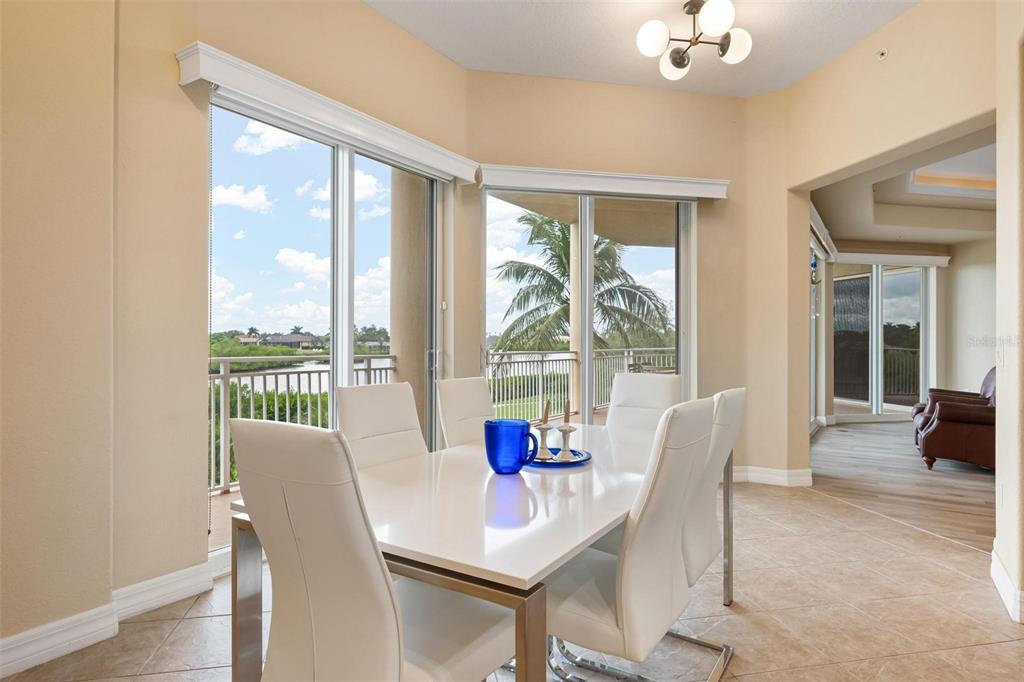 6100 Jessie Harbor Drive, Unit 202 Osprey, FL 34229 - Photo 45 of 83 a view of a dining room with furniture large windows and wooden floor