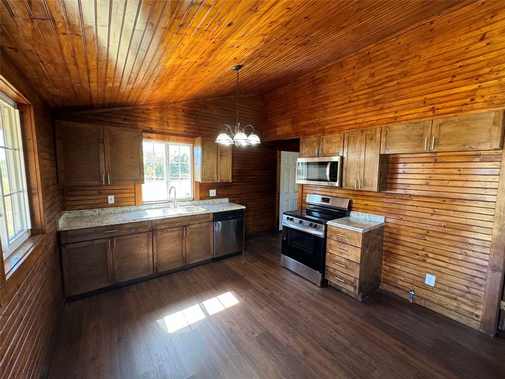 184 County Road Pattonville, TX 75468 - Photo 7 of 20 a large kitchen with stainless steel appliances wooden floors and wooden cabinets