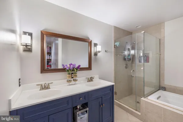 a bathroom with a tub sink mirror and shower