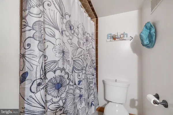 a bathroom with a toilet and a shower curtain