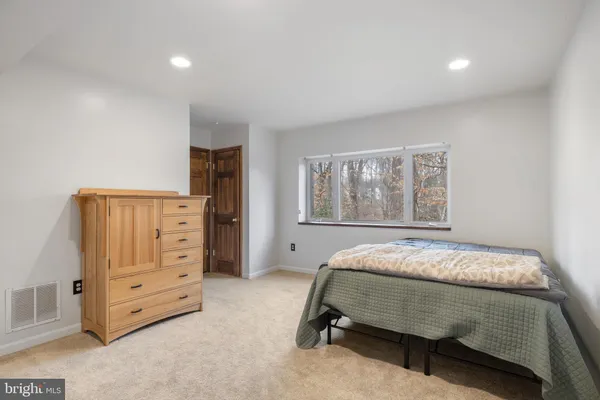 a spacious bedroom with a bed and a window