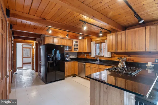a kitchen with stainless steel appliances granite countertop a refrigerator and wooden cabinets