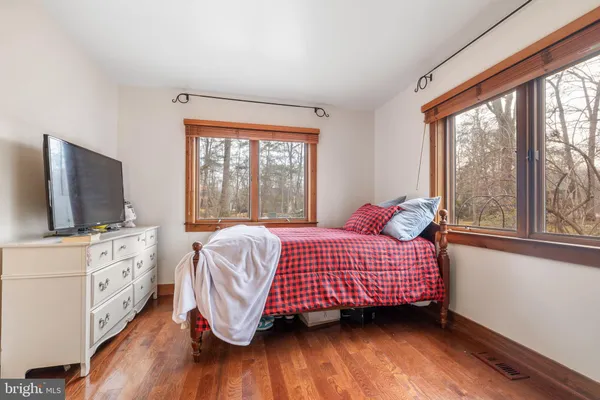 a bedroom with a bed and a flat tv screen on dresser