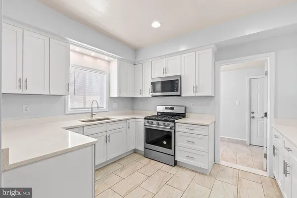 a kitchen with white cabinets and white appliances