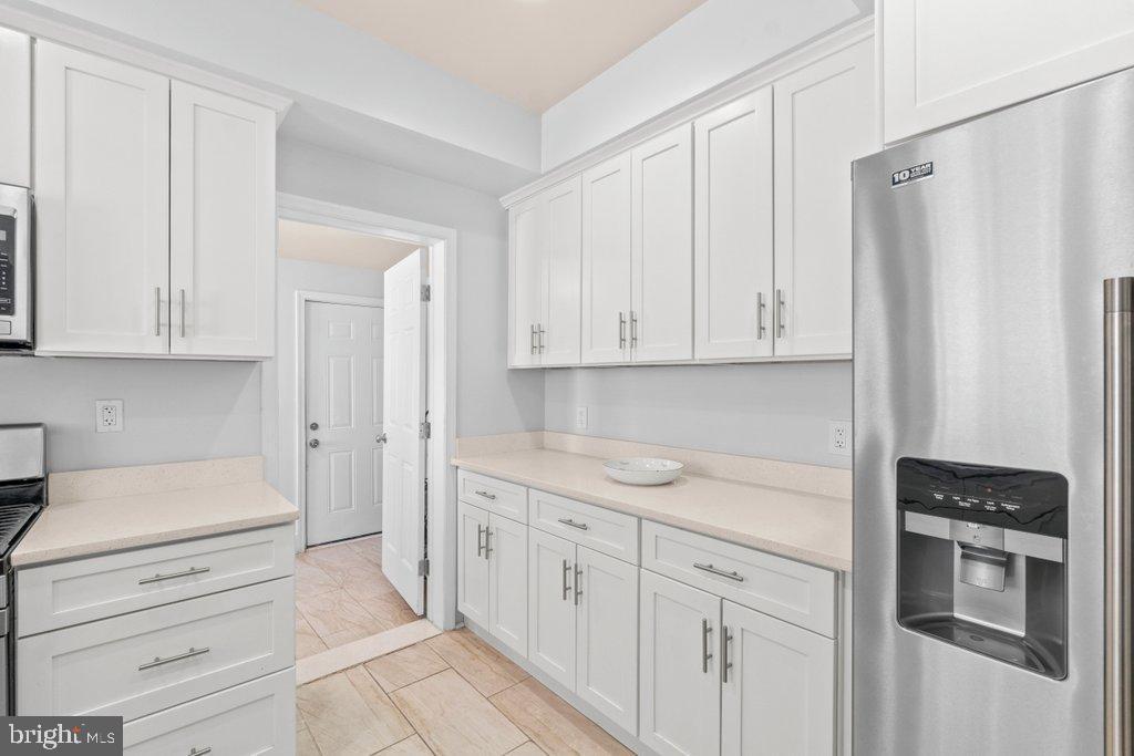 4919 Harford Road Baltimore, MD 21214 - Photo 15 of 48 a kitchen with white cabinets and white appliances