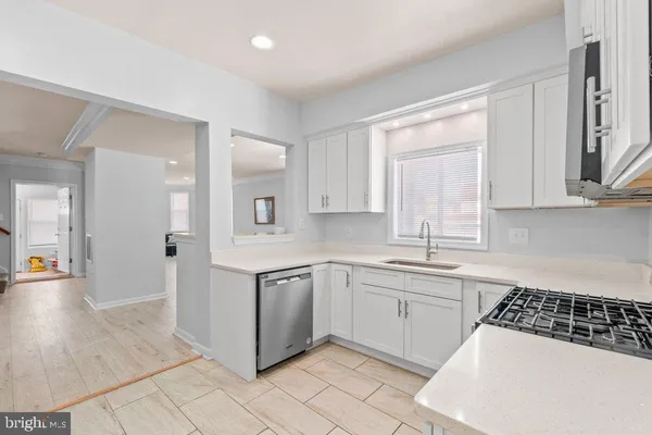 a kitchen with white cabinets appliances and a sink