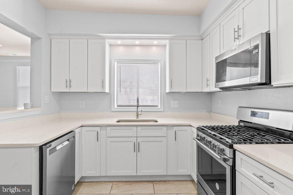 4919 Harford Road Baltimore, MD 21214 - Photo 17 of 48 a kitchen with white cabinets appliances and a sink