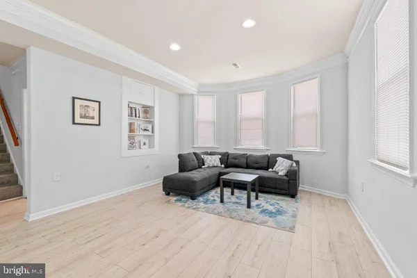 a living room with furniture and a dining table with wooden floor