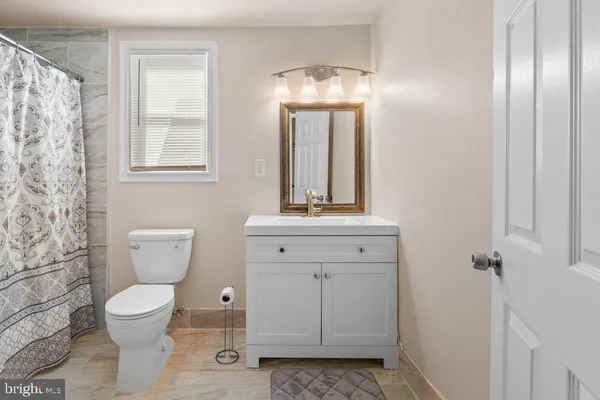 a bathroom with a toilet sink and mirror